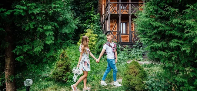 entreprise-de-nettoyage-femme-de-chambre-professionnelle-souriante-en-uniforme-au-travail-dans-la-ma 2 personnes main dans la main devant un chalet Vosges